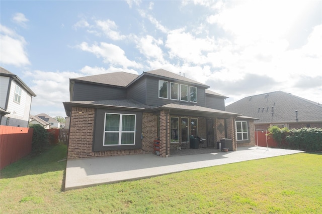 back of property featuring a lawn and a patio area