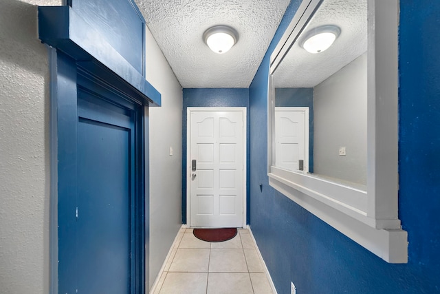 entryway featuring light tile patterned flooring and a textured ceiling