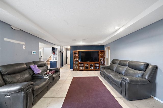 tiled living room featuring a textured ceiling