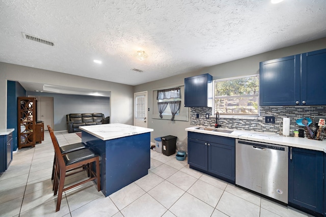 kitchen featuring stainless steel dishwasher, blue cabinets, and sink