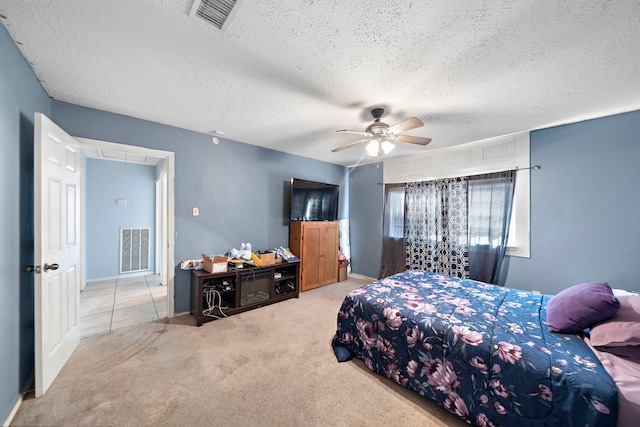 carpeted bedroom featuring ceiling fan and a textured ceiling