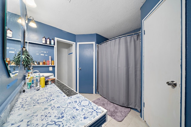 bedroom featuring light tile patterned floors and a textured ceiling