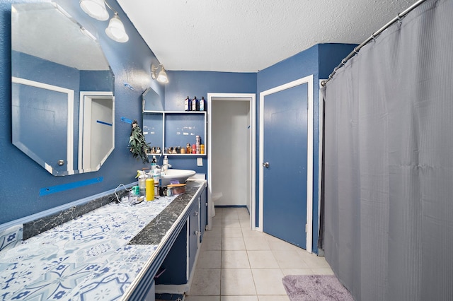 bathroom with tile patterned flooring, vanity, toilet, and a textured ceiling