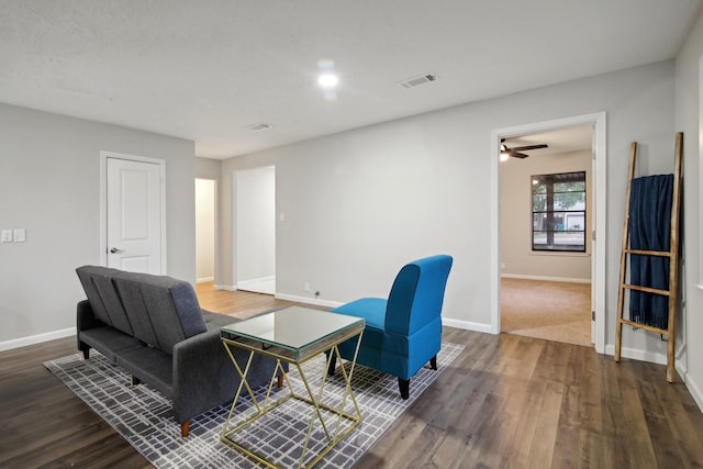 living room with ceiling fan and dark wood-type flooring