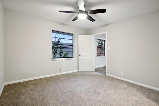 carpeted spare room with ceiling fan