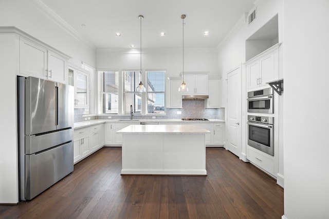 kitchen with white cabinets, dark hardwood / wood-style floors, a kitchen island, and appliances with stainless steel finishes