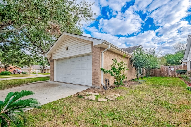 view of side of home with a lawn, concrete driveway, an attached garage, fence, and brick siding