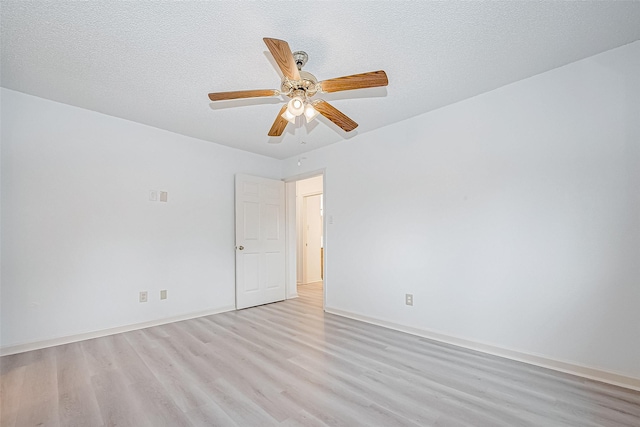 empty room with ceiling fan, a textured ceiling, and light wood finished floors