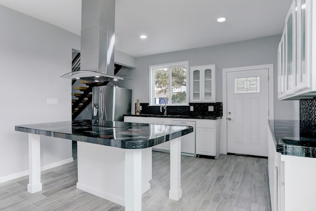 kitchen with a breakfast bar, stainless steel fridge, backsplash, and dishwasher