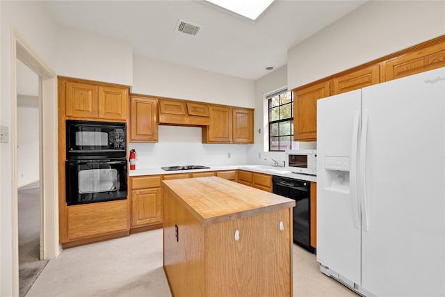 kitchen featuring sink, wooden counters, light carpet, a kitchen island, and black appliances