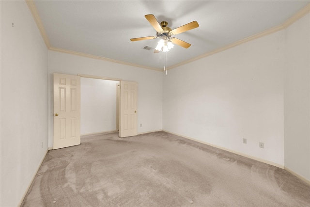 spare room with light carpet, ceiling fan, and crown molding