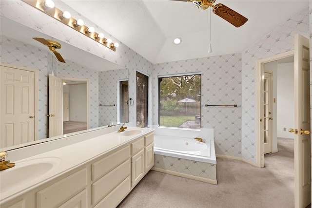 bathroom with tiled tub, ceiling fan, vanity, and vaulted ceiling