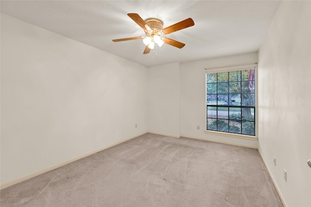 carpeted spare room featuring ceiling fan