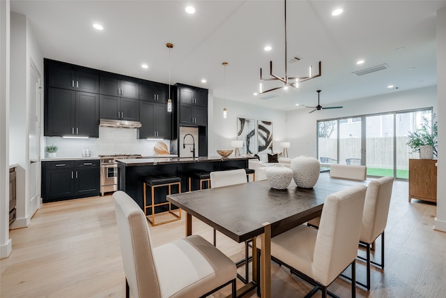 dining room with ceiling fan, sink, and light hardwood / wood-style flooring