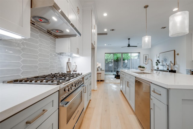 kitchen featuring pendant lighting, sink, tasteful backsplash, stainless steel appliances, and extractor fan