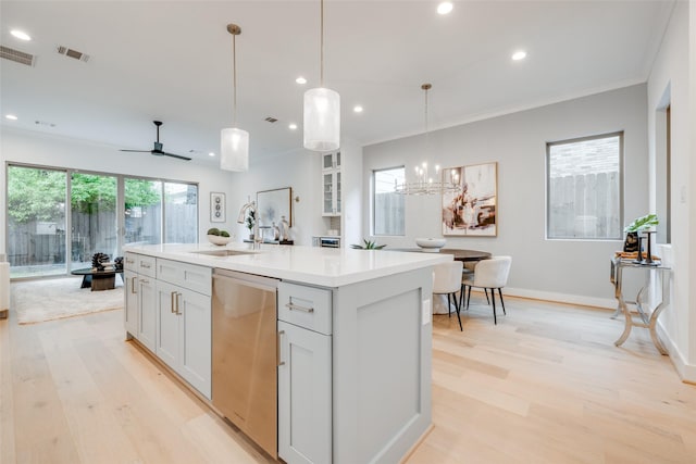 kitchen with ceiling fan with notable chandelier, sink, a center island with sink, dishwasher, and plenty of natural light