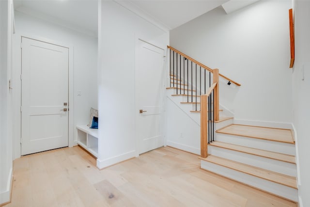 entrance foyer featuring light wood-type flooring and crown molding