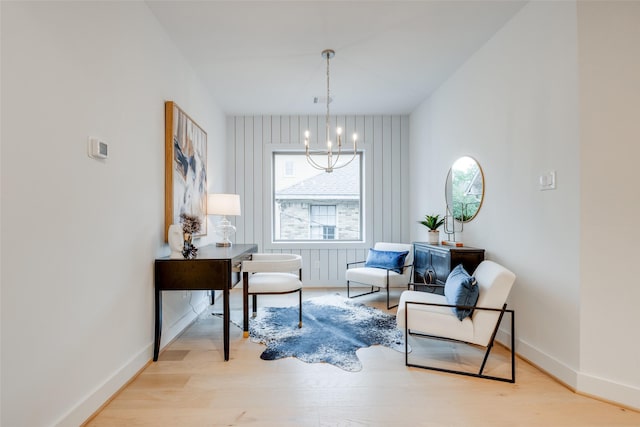 living area featuring light wood-type flooring and an inviting chandelier