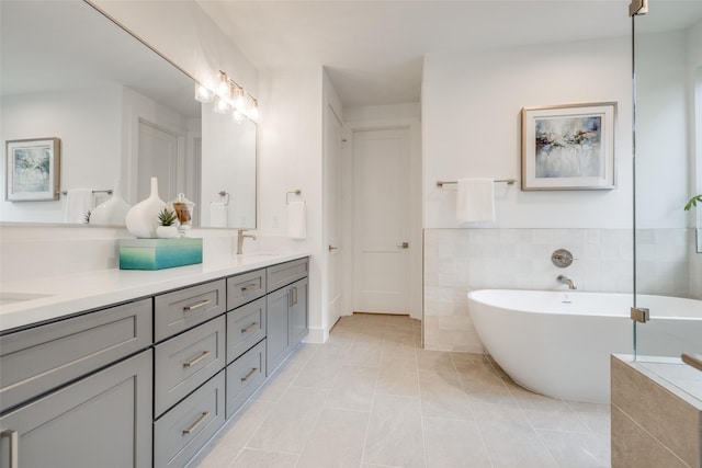 bathroom featuring vanity, tile patterned floors, tile walls, and a bathing tub