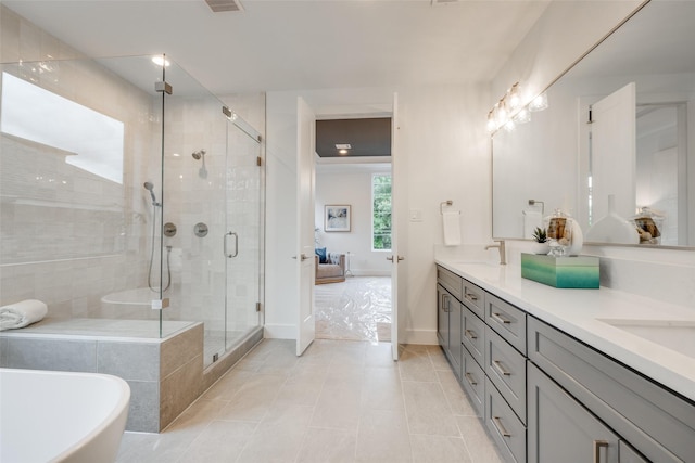 bathroom featuring tile patterned flooring, vanity, and plus walk in shower