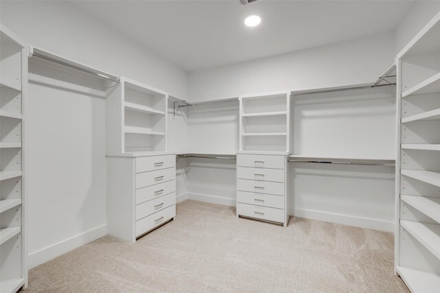 walk in closet with light colored carpet