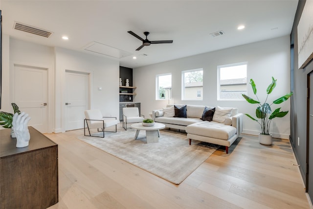 living room with ceiling fan and light hardwood / wood-style flooring