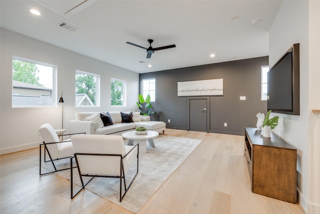 living room featuring light hardwood / wood-style flooring and ceiling fan