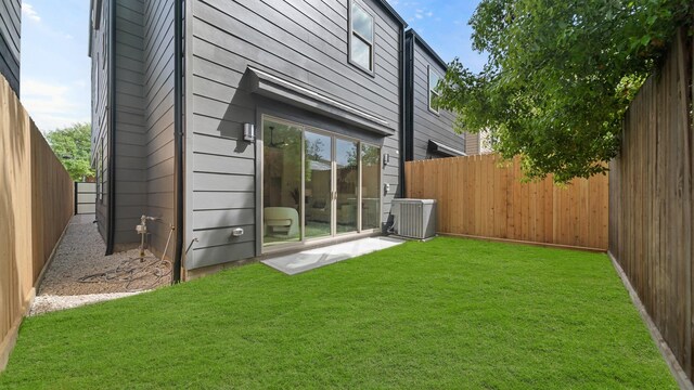 rear view of house with a yard and cooling unit