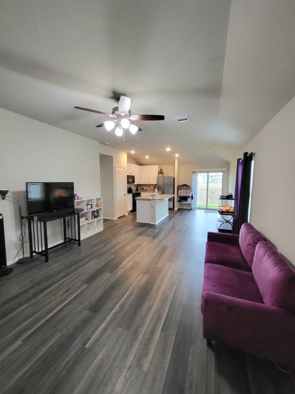 living room with ceiling fan and dark wood-type flooring