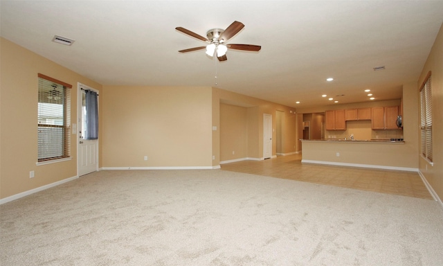 unfurnished living room with light carpet and ceiling fan