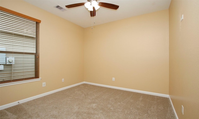 carpeted spare room featuring ceiling fan