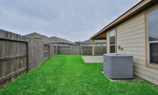 view of yard with central air condition unit and a patio