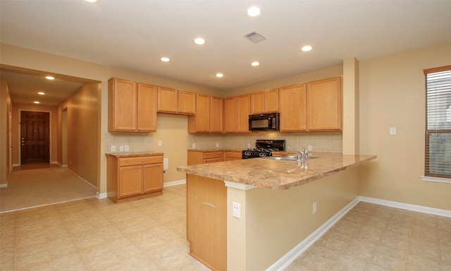 kitchen featuring kitchen peninsula, light brown cabinetry, sink, and black appliances