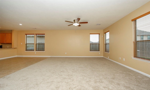 unfurnished living room featuring light carpet and ceiling fan