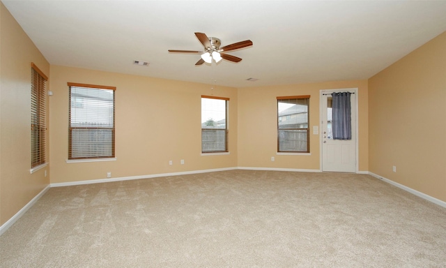 empty room with ceiling fan and light carpet