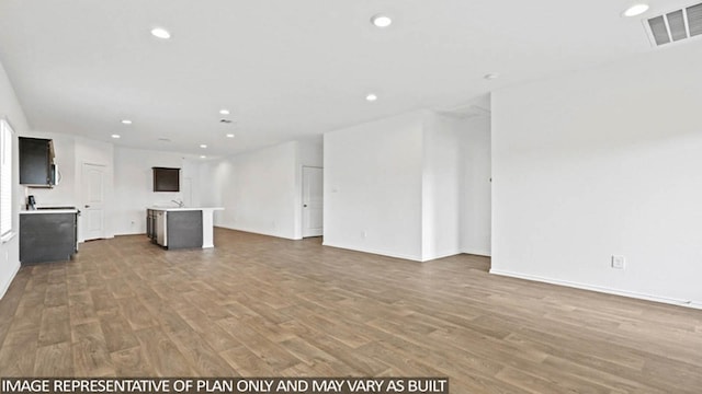 unfurnished living room with wood-type flooring and sink