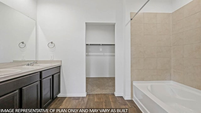 bathroom featuring hardwood / wood-style floors, vanity, and tiled shower / bath combo