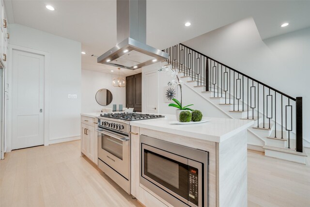 kitchen with recessed lighting, light wood-style flooring, appliances with stainless steel finishes, and island exhaust hood