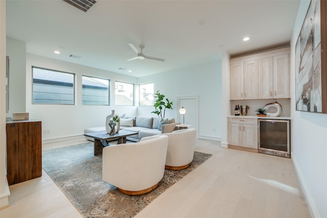 living area featuring visible vents, light wood-style flooring, a ceiling fan, recessed lighting, and wine cooler