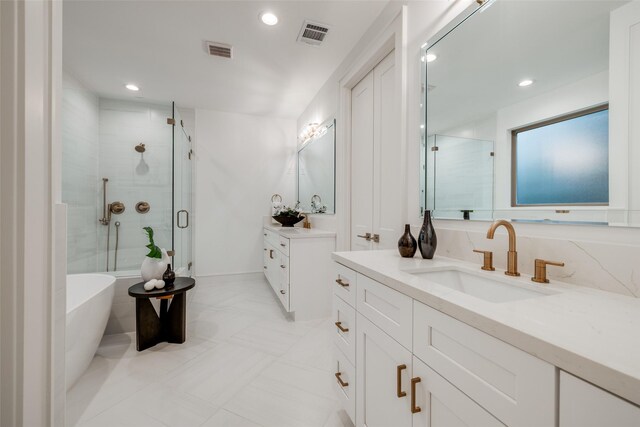 bathroom with visible vents, two vanities, a stall shower, a freestanding tub, and a sink