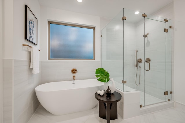 bathroom featuring a soaking tub, recessed lighting, a stall shower, and tile walls