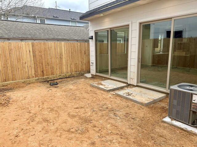 exterior space featuring central AC unit and fence