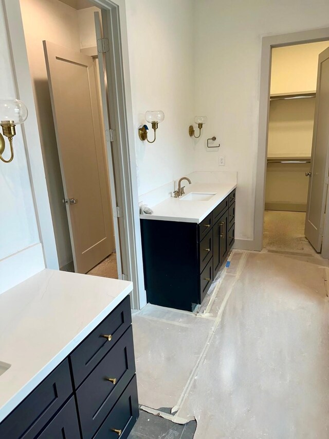 full bath featuring vanity and a walk in closet