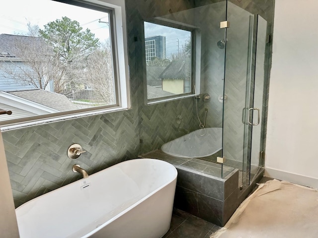 bathroom with tile patterned floors, a freestanding tub, and a stall shower