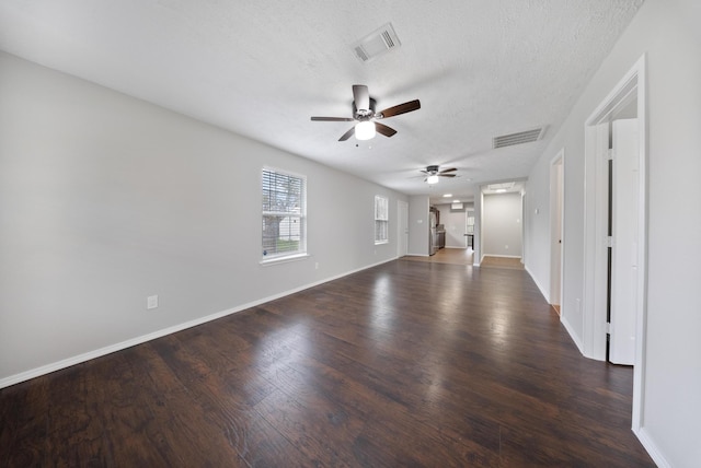 unfurnished living room featuring a textured ceiling, dark hardwood / wood-style flooring, and ceiling fan