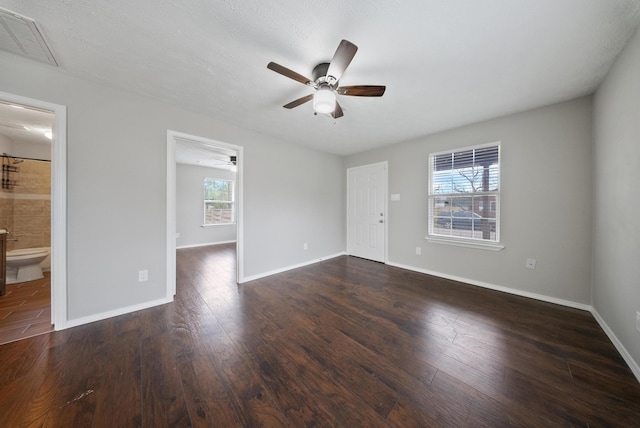 empty room with dark hardwood / wood-style floors and a wealth of natural light