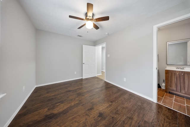 unfurnished bedroom with sink, dark hardwood / wood-style flooring, ceiling fan, and connected bathroom