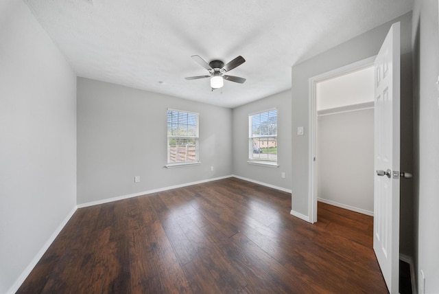 unfurnished bedroom featuring ceiling fan, dark hardwood / wood-style flooring, and a closet