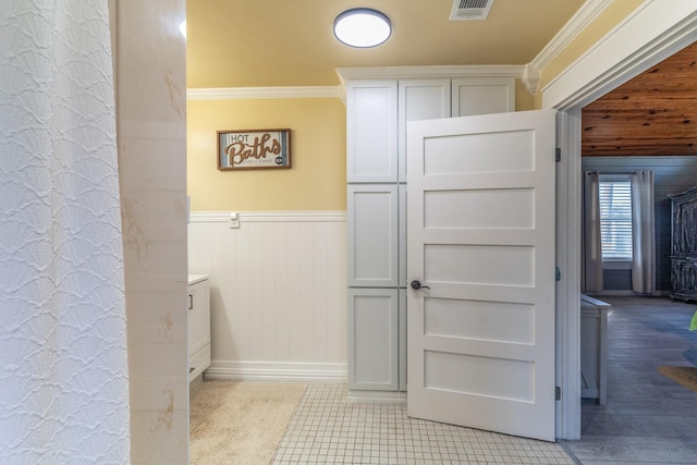 bathroom featuring wainscoting, visible vents, and ornamental molding