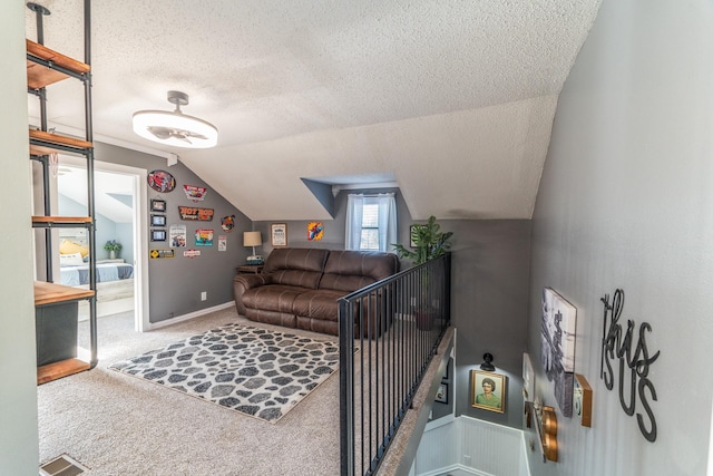 living area featuring carpet, visible vents, vaulted ceiling, and a textured ceiling